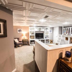 does a finished basement add value? Check out this white wooden paneled banister used as a room divider for a basement remodel.