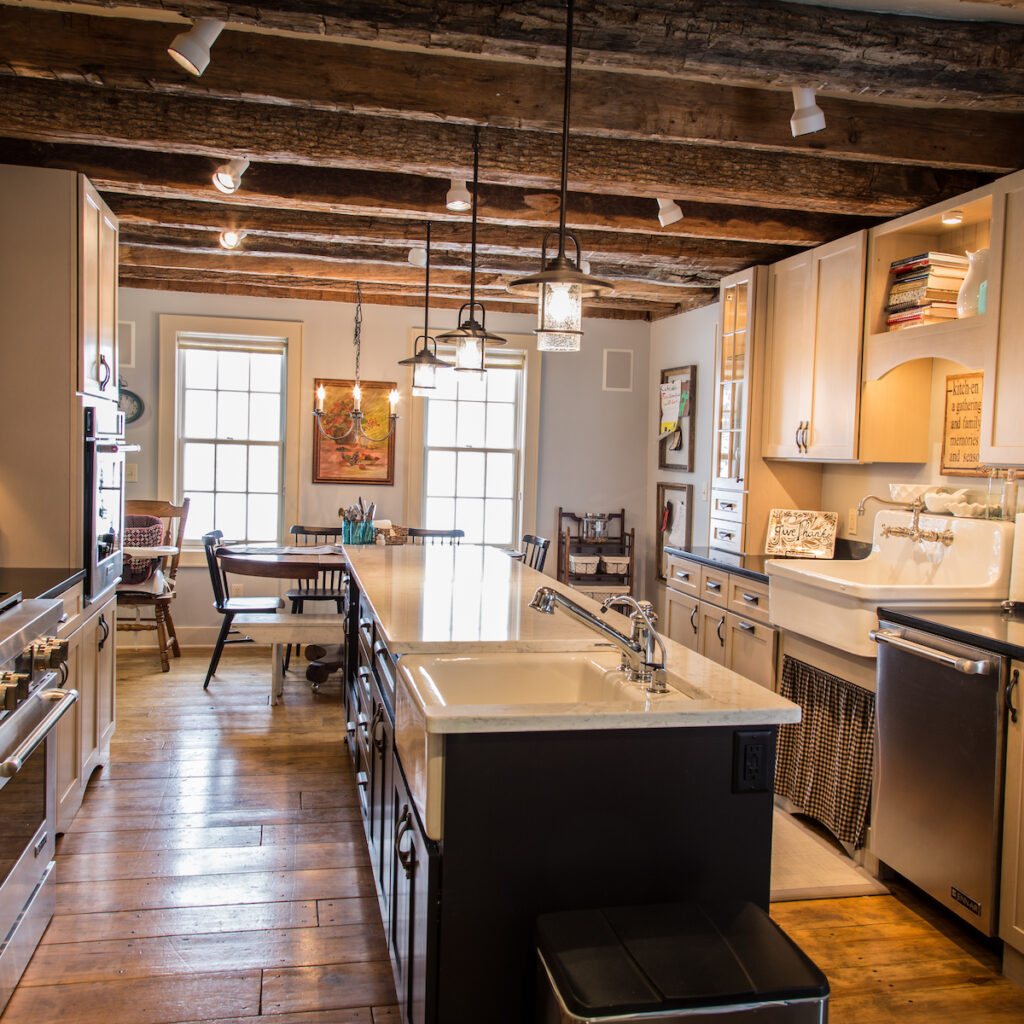 Custom home remodeling milwaukee: The Farmhouse Kitchen with kitchen island, wood ceiling beams, and wood floors